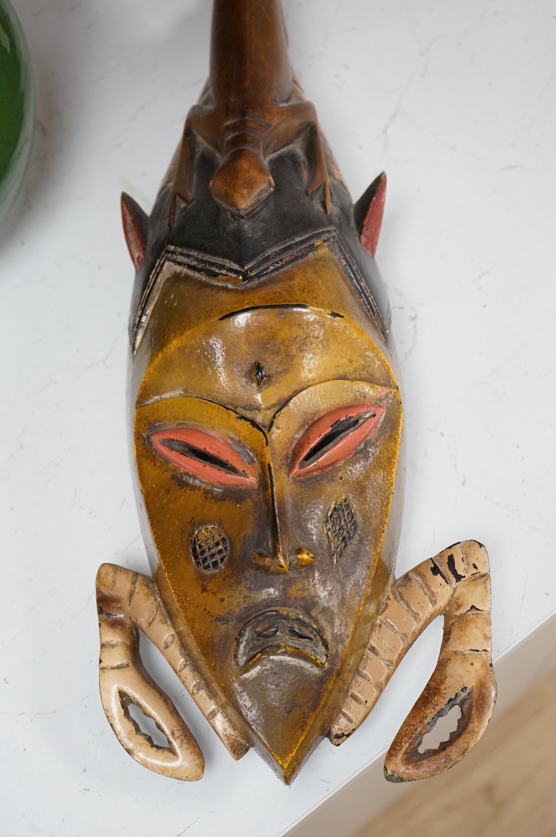 An early 20th century Tribal carved and painted mask from the Ivory Coast, 74cm in length